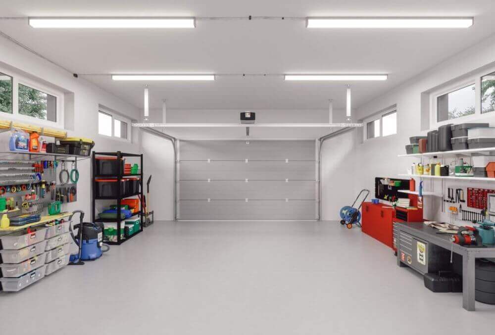 Well-lit garage with fluorescent lights and built-in storage cabinets.