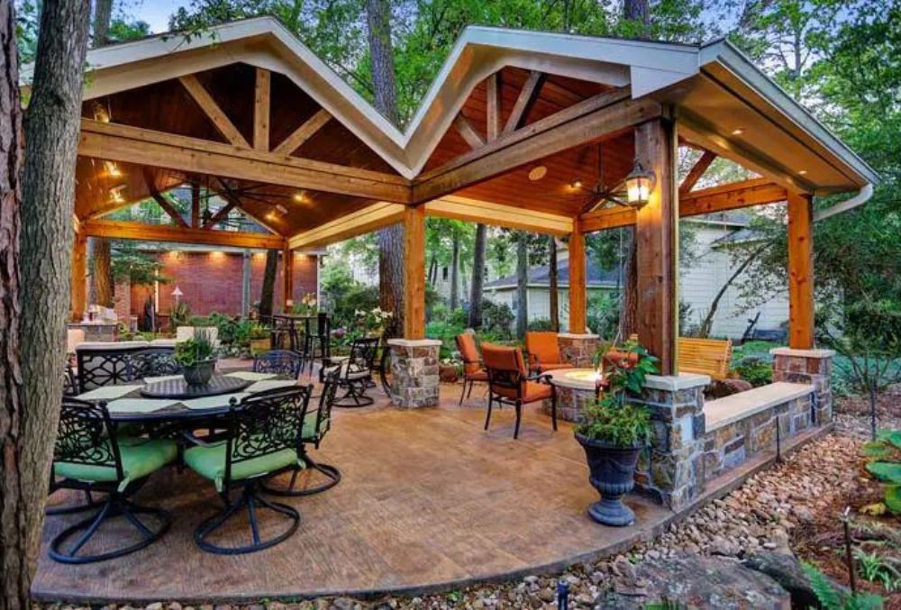 Elegant backyard structure with lighting, chairs, and stamped flooring.